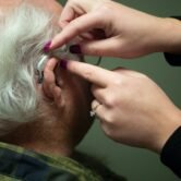 Audiologist preparing a patient for a hearing test