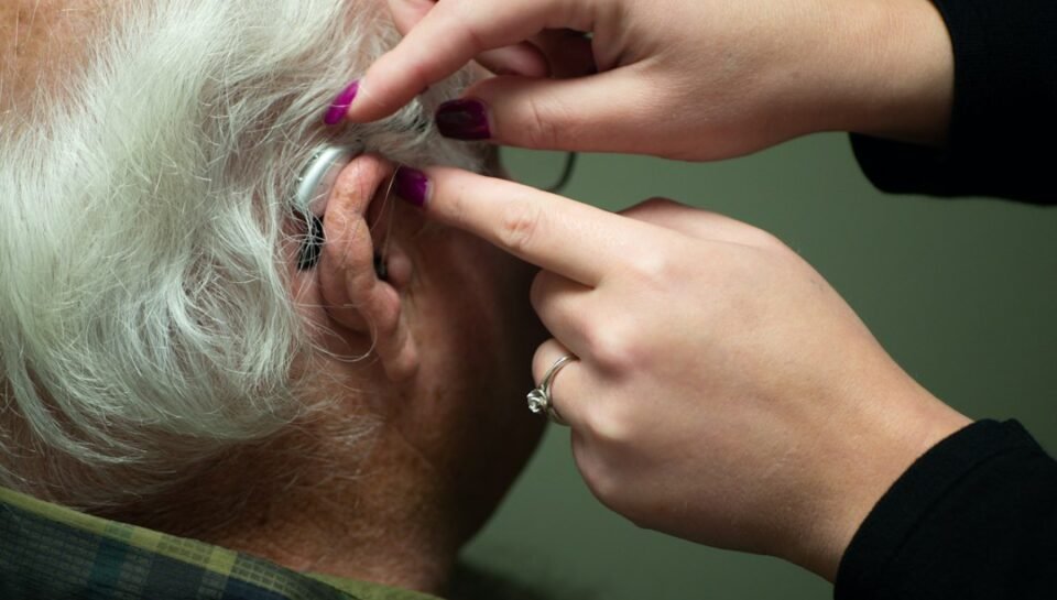 Audiologist preparing a patient for a hearing test