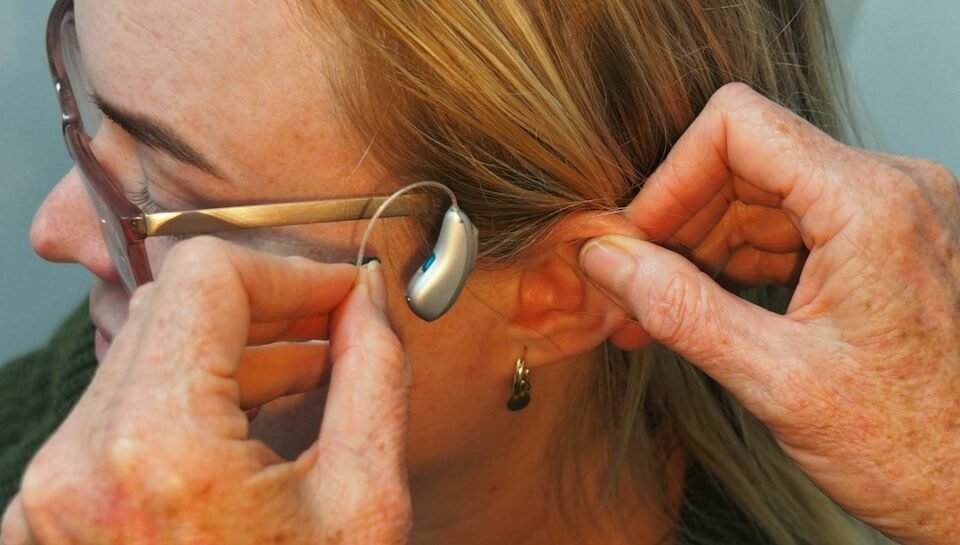 Audiologist fitting a receiver-in-canal hearing aid